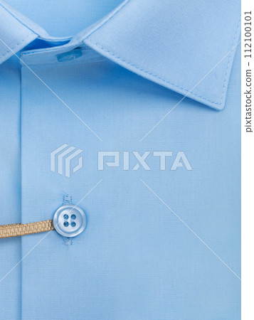 Close-up of a button placket on a light blue men's shirt Close-up of a button placket on a light blue men's shirt 112100101