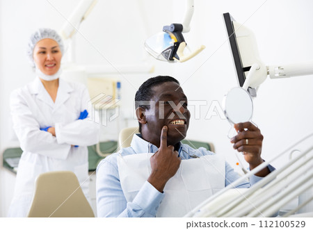 Man satisfied with result of teeth treatment at dental office Man satisfied with result of teeth treatment at dental office 112100529