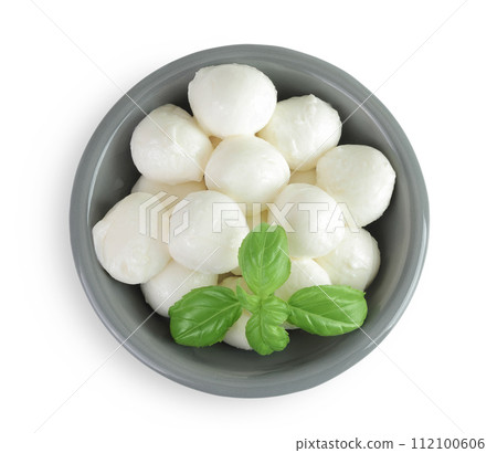 Mini mozzarella balls with basil in a ceramic bowl isolated on white background. Top view. Flat lay. 112100606