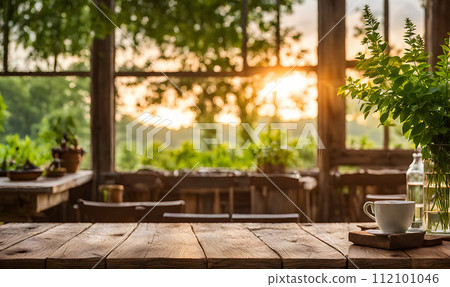 An empty wooden table in the foreground, with a blurred country house in the background against a verdant garden setting An empty wooden table in the foreground, with a blurred country house in the background against a verdant garden setting 112101046