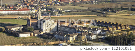 Aerial shot over Certosa di Pavia monastery with lawn fields 112101091