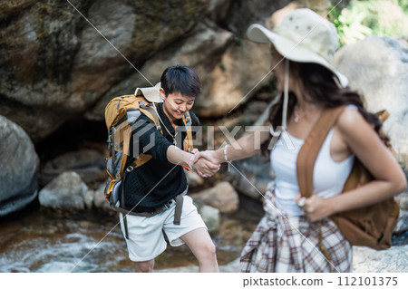 Happy LGBT Lesbian couple Travelers Hiking with Backpacks in waterfall Trail. LGBT Lesbian Couple Hikers with backpacks walks in mountains in vacation Happy LGBT Lesbian couple Travelers Hiking with Backpacks in waterfall Trail. LGBT Lesbian Couple Hikers with backpacks walks in mountains in vacation 112101375