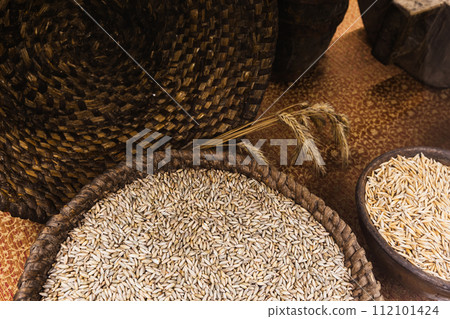 Rye grains lie in a basket and clay bowl 112101424