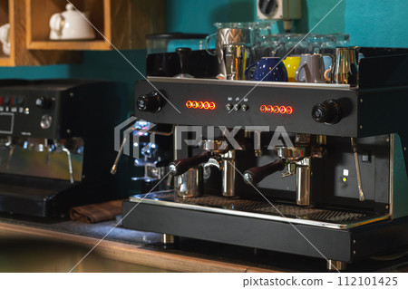 Professional black coffee machine stands on a desk Professional black coffee machine stands on a desk 112101425
