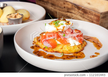 Potato pancake with salmon and poached egg, close up photo Potato pancake with salmon and poached egg, close up photo 112101443