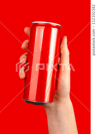 Hand holding blank red can, soda drink in metal tin jar, bottle, mockup 112102382