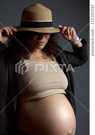 Charming sexy pregnant woman with naked belly, in last trimester of pregnancy, isolated fashion gray studio background. 112102592