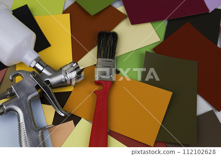a paint spray gun at work at the workplace in the workshop. Paint samples. 112102628