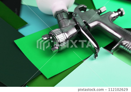 a paint spray gun at work at the workplace in the workshop. Paint samples. 112102629