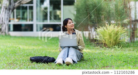 Young Asian student sitting and using laptop at university before class room. education, back to school concept 112103286