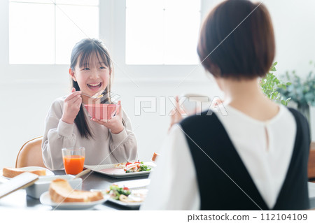 Parent and child eating rice in the dining room 112104109