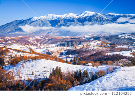 Carpathian Mountains, Romania. Winter snowy landscape with Sirnea village and Bucegi Mountains. 112104293