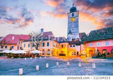 Sibiu, Romania. Morning dusk with Council Tower in Lesser Square. Medieval city in Transylvania. Sibiu, Romania. Morning dusk with Council Tower in Lesser Square. Medieval city in Transylvania. 112104323