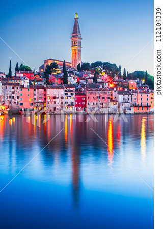 Rovinj - Istria Peninsula, Croatia. Twilight with old town harbor water reflection. Rovinj - Istria Peninsula, Croatia. Twilight with old town harbor water reflection. 112104339