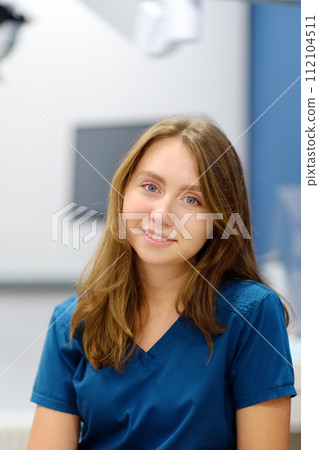 Vertical portrait of female ENT doctor during appointment of patient in medical office. Professional otolaryngologist is on workplace. Beautiful woman looking at camera Vertical portrait of female ENT doctor during appointment of patient in medical office. Professional otolaryngologist is on workplace. Beautiful woman looking at camera 112104511