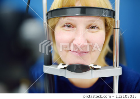 Close up mature female patient during visit by oculist for vision checkup. 112105013