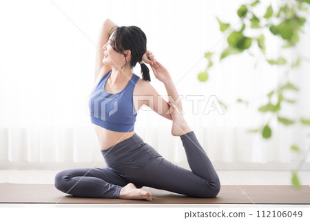 Beautiful woman doing yoga in pigeon pose Beautiful woman doing yoga in pigeon pose 112106049