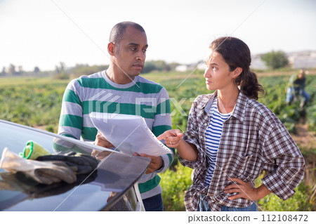 Delivery courier invites the farmer to sign documents on farmer field 112108472