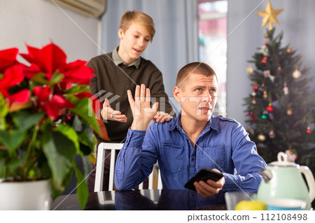 Son asks for forgiveness after quarrel during Christmas celebration closeup Son asks for forgiveness after quarrel during Christmas celebration closeup 112108498