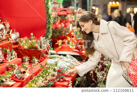 Cheerful woman looking for New Year decorations in street market 112108611