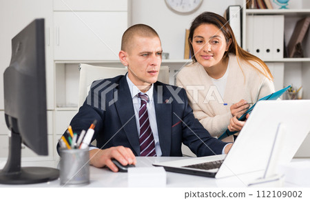 Successful businessman talking to female colleague Successful businessman talking to female colleague 112109002