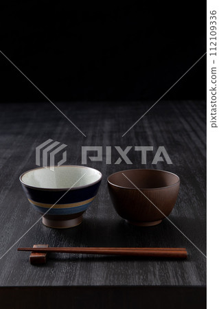 日本食物背景、附碗和筷子的黑色餐桌 日本食物背景、附碗和筷子的黑色餐桌 112109336