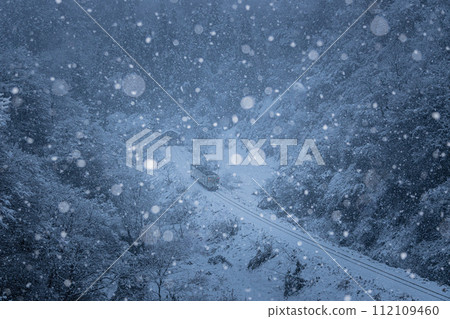 Ojiya City, Niigata Prefecture, Iiyama Line: A one-car train running through steep mountains with beautiful falling snow Ojiya City, Niigata Prefecture, Iiyama Line: A one-car train running through steep mountains with beautiful falling snow 112109460