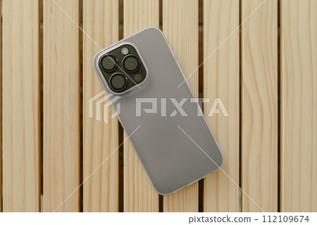 Back cover of mobile phone wearing plastic silicone white matte case on table. Back cover of mobile phone wearing plastic silicone white matte case on table. 112109674