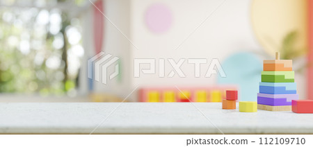 A presentation space on a table features colorful kid's toys in a kid's playroom or nursery. 112109710