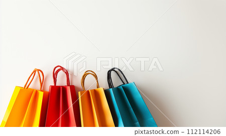 A row of colorful shopping bags lined up against a white background, representing the excitement and variety of a successful shopping spree 112114206