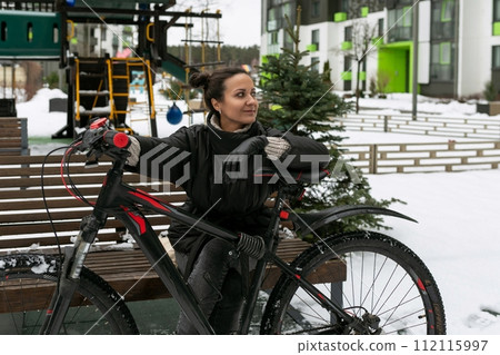 Lifestyle concept, young brunette woman out on the street with a bicycle Lifestyle concept, young brunette woman out on the street with a bicycle 112115997