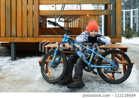 A male child rides a sports bike in the cold season A male child rides a sports bike in the cold season 112116084