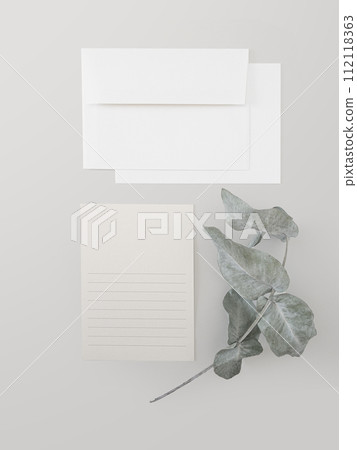 Top view white envelope with postcard and eucalyptus branch on light gray.  112118363