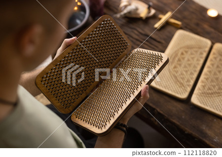 Sadhu board, yoga board with nails, guy stands on the board with nails, yoga concept 112118820