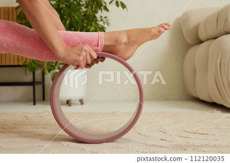 young flexible girl doing gymnastics, flexibility and stretching using a yoga wheel online on a white background young flexible girl doing gymnastics, flexibility and stretching using a yoga wheel online on a white background 112120035