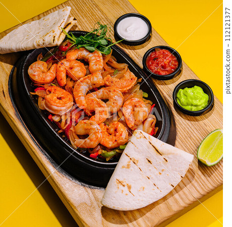 Fried large shrimp with onions and peppers in a frying pan Fried large shrimp with onions and peppers in a frying pan 112121377