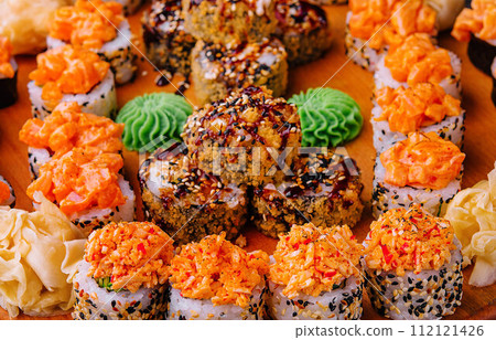 Tasty appetizing sushi rolls set on wooden board Tasty appetizing sushi rolls set on wooden board 112121426