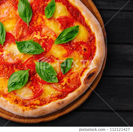 Pizza Margherita on black wood background Pizza Margherita on black wood background 112121427