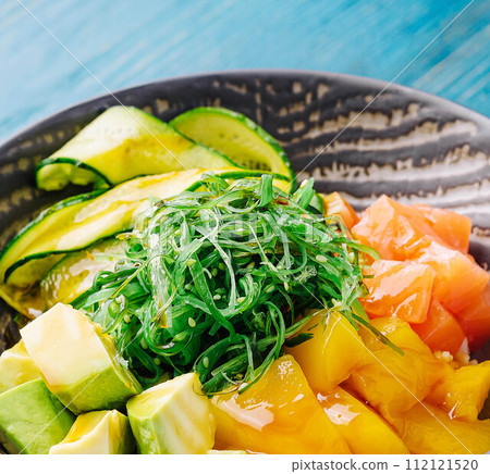 poke bowl with salmon on wood 112121520