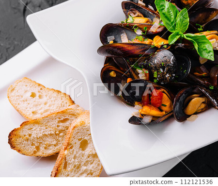 Delicious seafood mussels with with sauce and parsley Delicious seafood mussels with with sauce and parsley 112121536