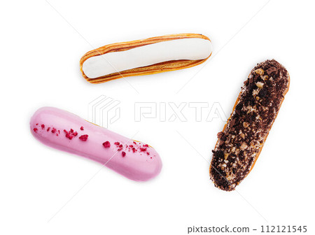 three different types of French eclairs on a white plate isolated on white background three different types of French eclairs on a white plate isolated on white background 112121545