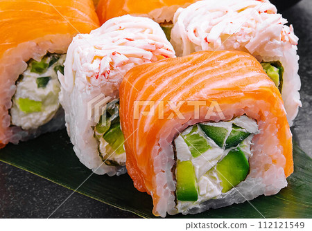 sushi rolls with salmon and crab on black plate sushi rolls with salmon and crab on black plate 112121549
