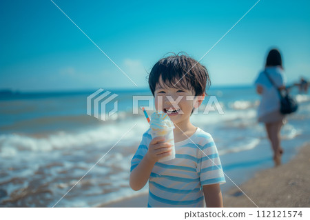 Boy eating ice cream at the beach in summer 112121574