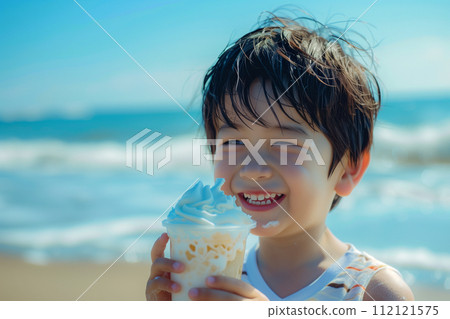 Boy eating ice cream at the beach in summer Boy eating ice cream at the beach in summer 112121575