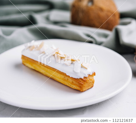 french eclair with coconut on plate 112121637