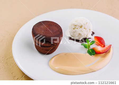 White plate with chocolate fondant cake White plate with chocolate fondant cake 112121661