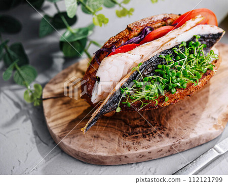 Mackerel fish sandwich on wooden board Mackerel fish sandwich on wooden board 112121799