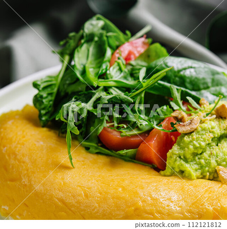 Omelette Served with Avocado puree and Cherry Tomatoes close up 112121812