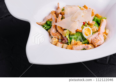 Caesar salad with grilled chicken meat, fresh lettuce, parmesan cheese and fried croutons Caesar salad with grilled chicken meat, fresh lettuce, parmesan cheese and fried croutons 112122046