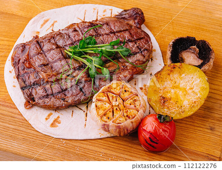 Grilled Tenderloin steak with vegetables on wood Grilled Tenderloin steak with vegetables on wood 112122276